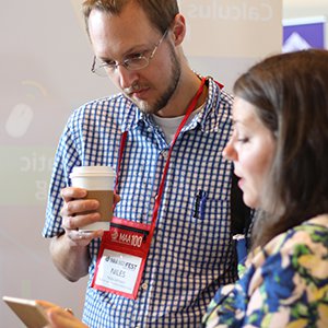 Educational Partnerships Manager Jami Mathewson shows an interested instructor our Dashboard course management software at MathFest 2016.