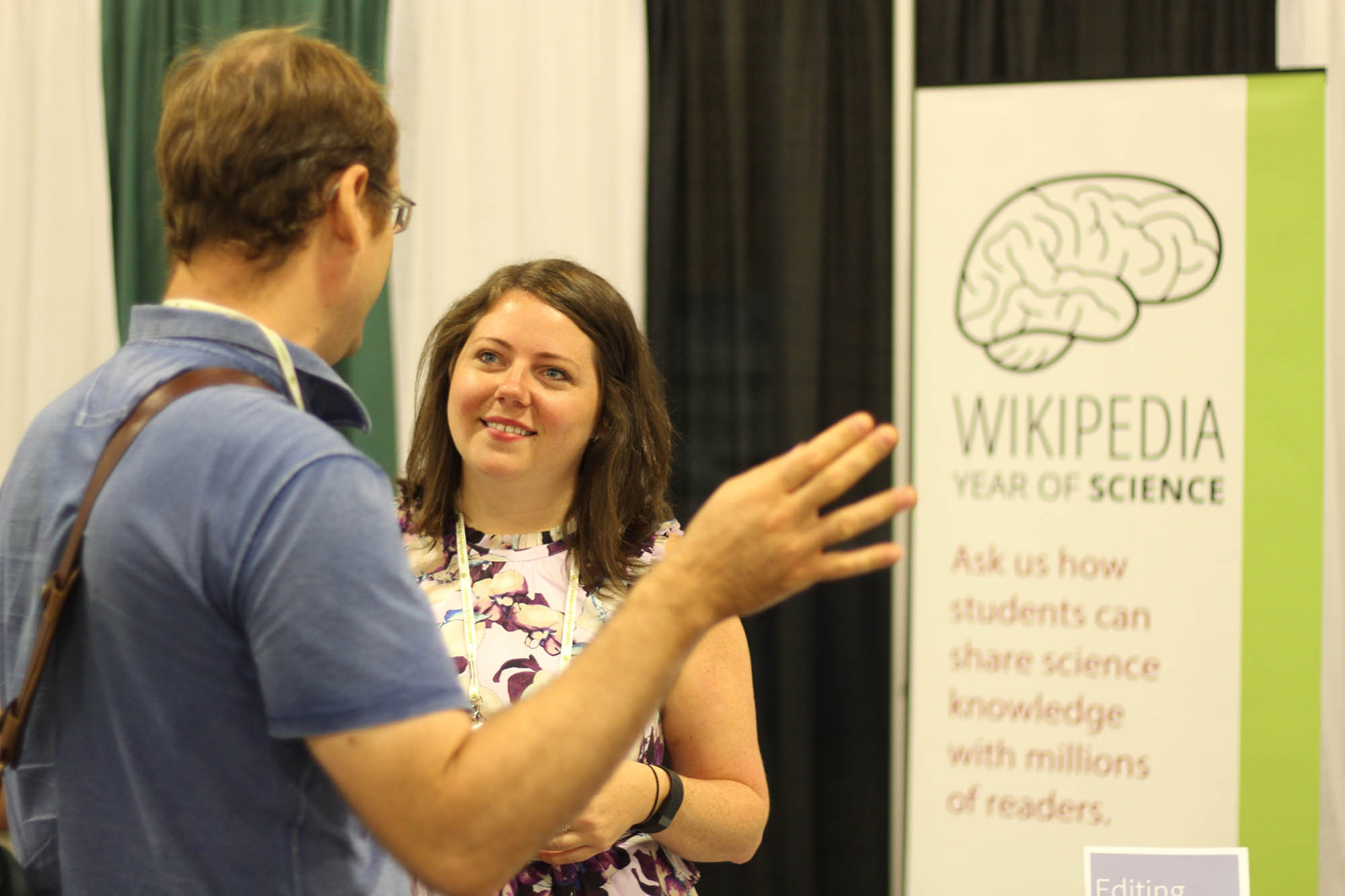 Educational Partnerships Manager Jami Mathewson speaks with an attendee at the Ecological Society of America conference.