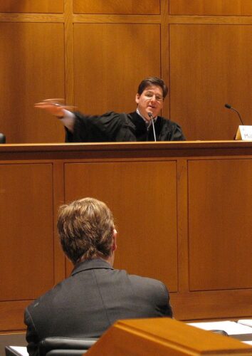 Judge on the stand speaking to a lawyer