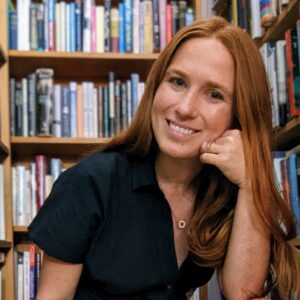 Megan Newsome in front of bookshelves