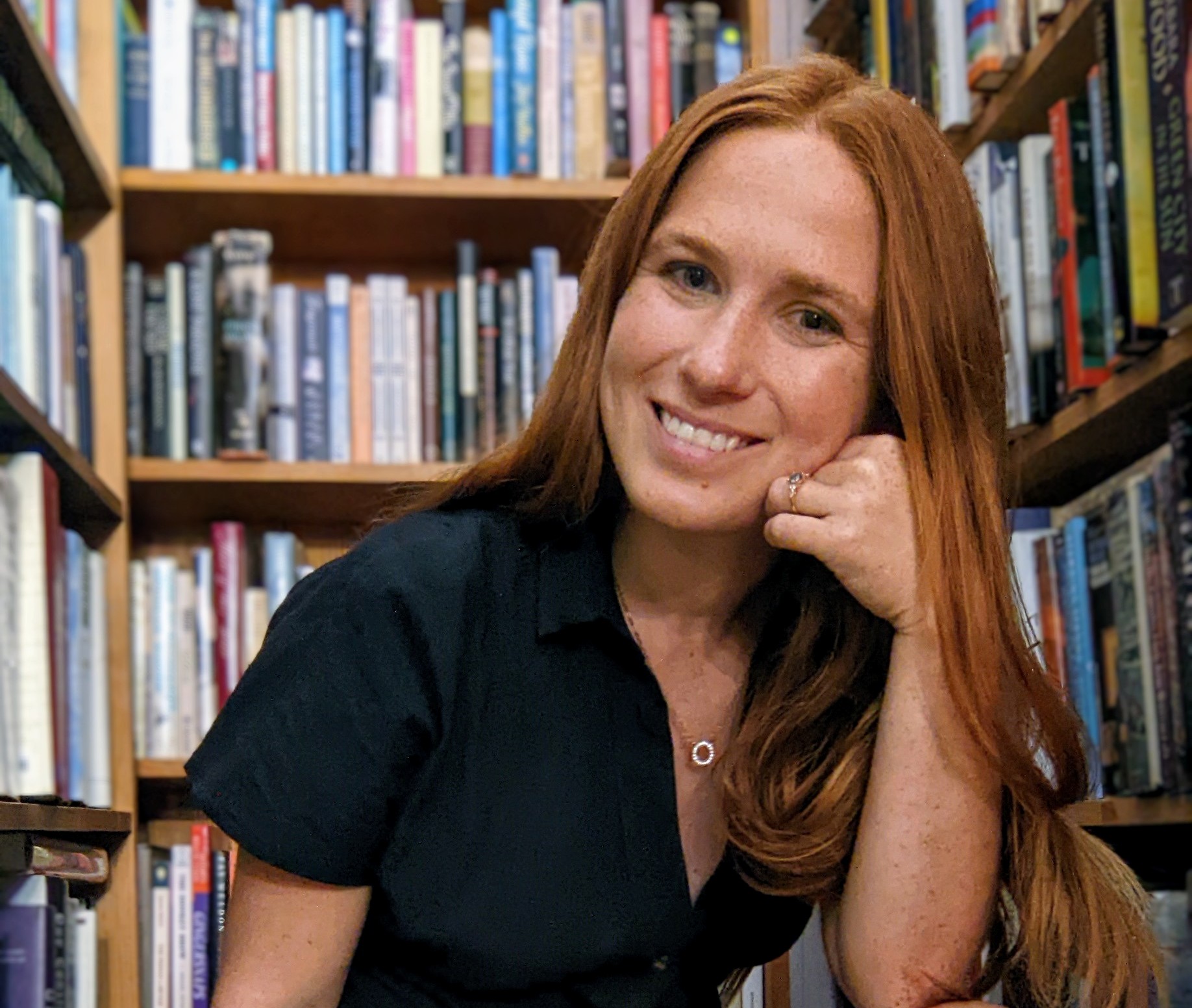 Megan Newsome in front of bookshelves